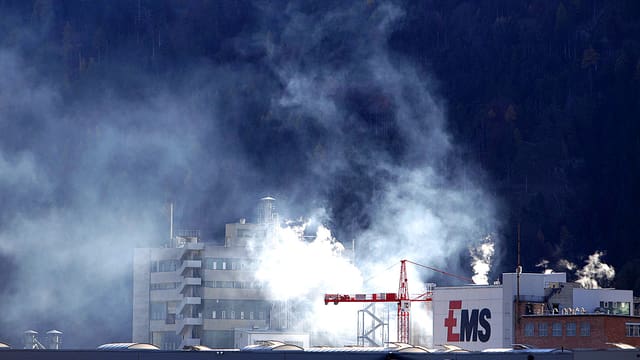 Ansicht des EMS-Firmengeländes. Dicke weisse Nebel stehen über den Gebäuden. Ansicht des EMS-Firmengeländes. Dicke weisse Nebel stehen über den Gebäuden.