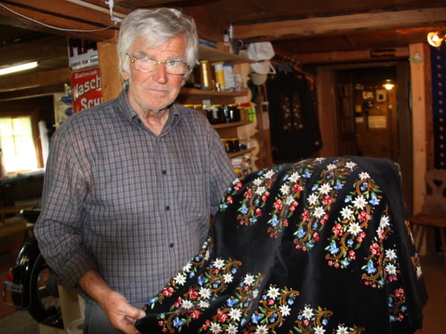 Der Handsticker zeigt schwarzen Samtstoff, der mit vielen farbigen Blumen bestickt ist. Der Handsticker zeigt schwarzen Samtstoff, der mit vielen farbigen Blumen bestickt ist.