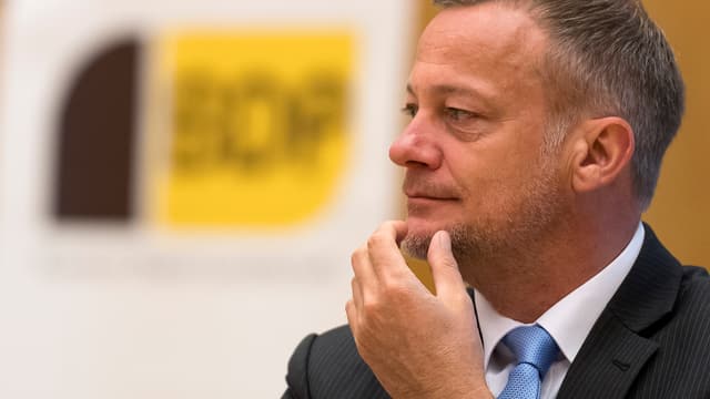 Landolt vor einem BDP-Parteilogo, er hält die linke Hand ans Kinn. Landolt vor einem BDP-Parteilogo, er hält die linke Hand ans Kinn.