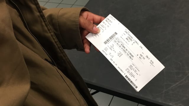 Eine Person hält ein Ticket in den Händen. Eine Person hält ein Ticket in den Händen.