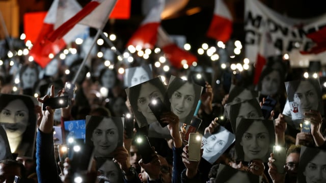Demonstranten bei Nacht, viele tragen ein Foto der ermordeten Journalistin Daphne Caruana Galizia. Demonstranten bei Nacht, viele tragen ein Foto der ermordeten Journalistin Daphne Caruana Galizia.