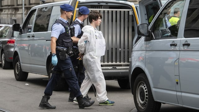 Polizisten führen einen Klimaaktivisten ab, der zuvor beim Eingang der Bank Credit Suisse demonstriert hatte. Polizisten führen einen Klimaaktivisten ab, der zuvor beim Eingang der Bank Credit Suisse demonstriert hatte.