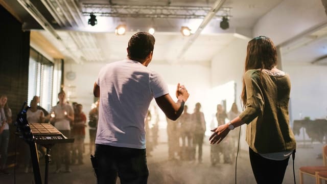 Ein Mann und eine Frau auf der Bühne. Sie sind gegen ein Publikum gerichtet. Ein Mann und eine Frau auf der Bühne. Sie sind gegen ein Publikum gerichtet.