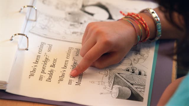 Schülerin zeigt mit Finger auf eine englische Textpassage in ihrem Lernordner Schülerin zeigt mit Finger auf eine englische Textpassage in ihrem Lernordner