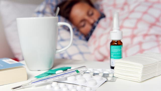 Frau liegt wegen Grippe im Bett.