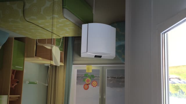 Ein Schlafzimmer, darin ein weisser Kasten neben einem Bett. Ein Schlafzimmer, darin ein weisser Kasten neben einem Bett.