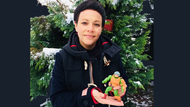 Frau präsentiert eine bunte Plastikfigur in die Kamera. Frau präsentiert eine bunte Plastikfigur in die Kamera.
