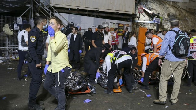 Rettungskräfte transportieren die Toten nach der Massenpanik ab. Rettungskräfte transportieren die Toten nach der Massenpanik ab.