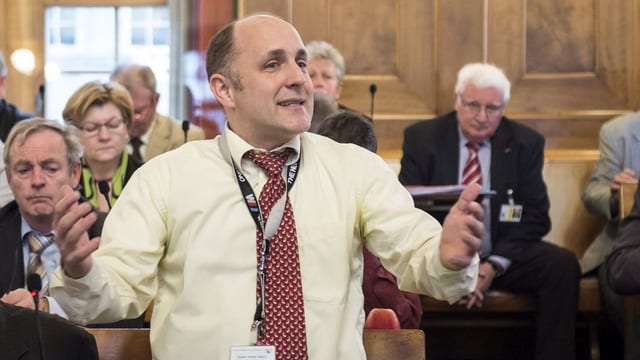 Der Zürcher SVP-Kantonsrat Claudio Schmid steht im Zürcher kantonsrat und fordert während einer Debatte ein Autoverbot für Sozialhilfebezüger. Der Zürcher SVP-Kantonsrat Claudio Schmid steht im Zürcher kantonsrat und fordert während einer Debatte ein Autoverbot für Sozialhilfebezüger.