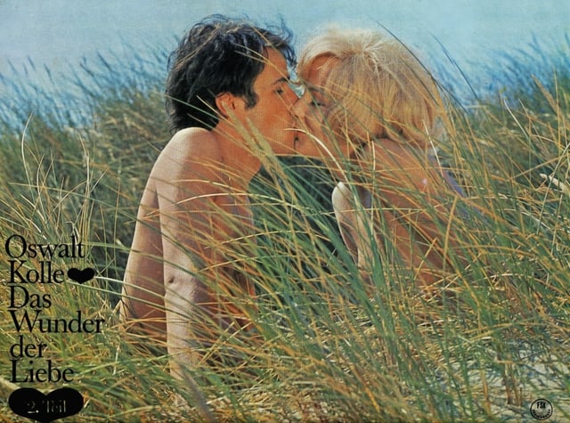 Ein Filmplakat zeigt zwei nackte Menschen, die sich im Gras küssen. Ein Filmplakat zeigt zwei nackte Menschen, die sich im Gras küssen.