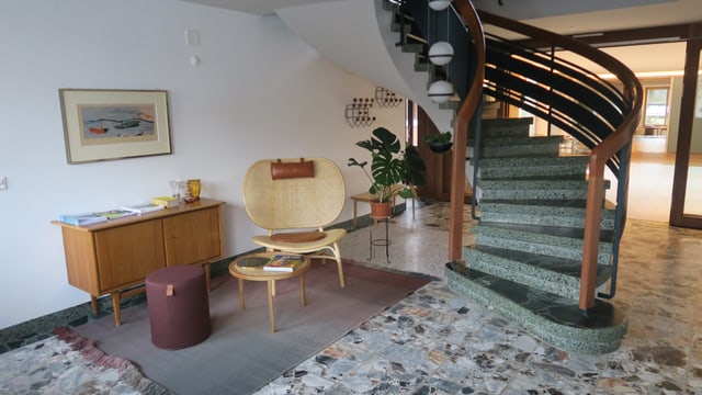 Eine Treppe führt von einem Raum mit Sitzbereich in den oberen Stock. Eine Treppe führt von einem Raum mit Sitzbereich in den oberen Stock.