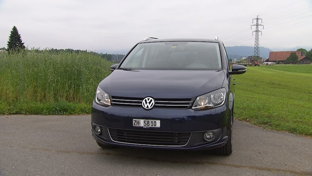 Dunkelblauer VW-Van steht auf einer Nebenstrasse. Dunkelblauer VW-Van steht auf einer Nebenstrasse.