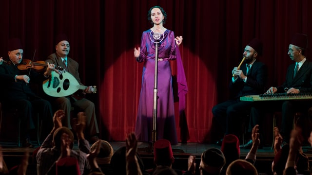 Eine Frau steht auf der Bühne und singt. Eine Frau steht auf der Bühne und singt.