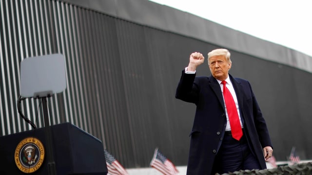 Trump vor einer Mauer. Er ballt die Faust. Trump vor einer Mauer. Er ballt die Faust.