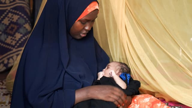 Eine Frau im Flüchtlingslager Dadaab stillt ein Kind. Eine Frau im Flüchtlingslager Dadaab stillt ein Kind.
