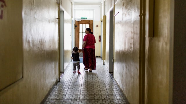 Eine Frau und ein kleines Kind am Ende eines düsteren Ganges. Eine Frau und ein kleines Kind am Ende eines düsteren Ganges.