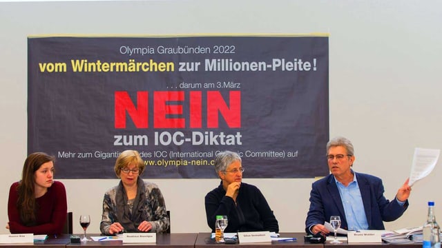 Drei Frauen und ein Mann sitzen vor einem Plakat an einer Pressekonferenz Drei Frauen und ein Mann sitzen vor einem Plakat an einer Pressekonferenz