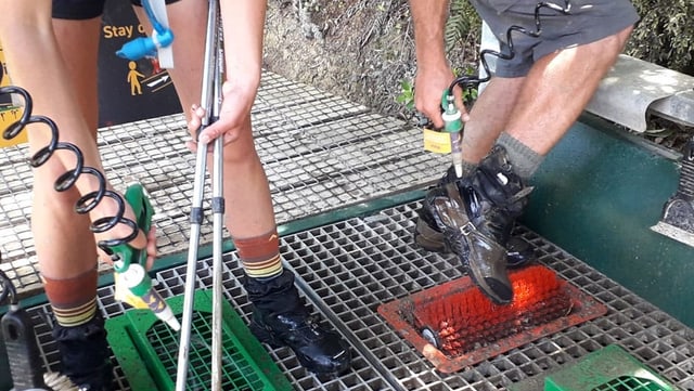 Zwei Wanderer mit nackten Beinen spirtzen ihre Schuhe ab. Zwei Wanderer mit nackten Beinen spirtzen ihre Schuhe ab.