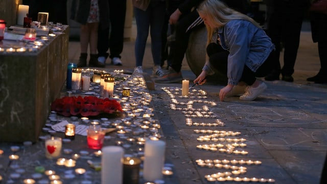 Eine junge Frau zündet Kerzen an. Eine junge Frau zündet Kerzen an.