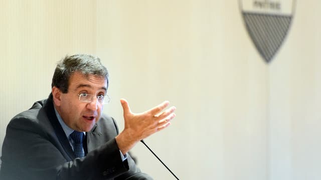 Pascal Broulis spricht sitzend am Mikrofon im Hintergrund das Waadtländer Wappen. Pascal Broulis spricht sitzend am Mikrofon im Hintergrund das Waadtländer Wappen.