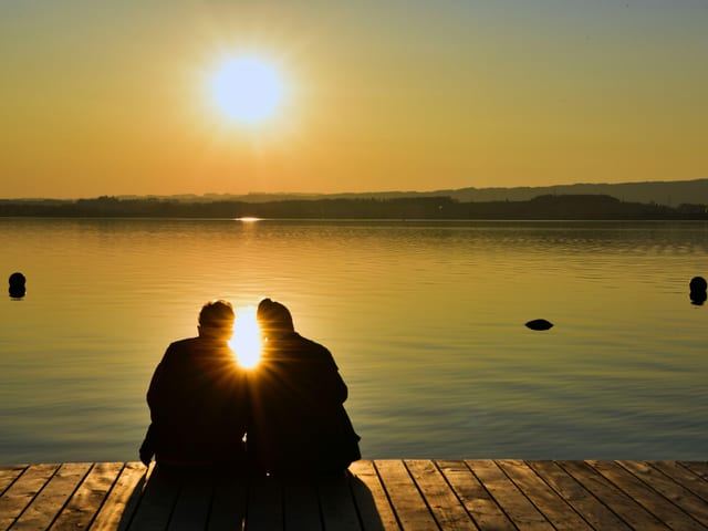 Ein paar am Seeufer bei Sonnenuntergang. Ein paar am Seeufer bei Sonnenuntergang.