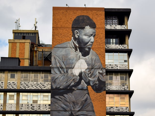 Mural des jungen Nelson Madela mit Boxhandschuhen auf einer Hausfassade. Mural des jungen Nelson Madela mit Boxhandschuhen auf einer Hausfassade.