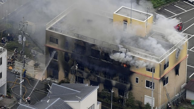 Blick von oben auf das braune Animationsstudio. Aus dem Studio steigt Rauch aus, man sieht noch kleine Flammen. Blick von oben auf das braune Animationsstudio. Aus dem Studio steigt Rauch aus, man sieht noch kleine Flammen.