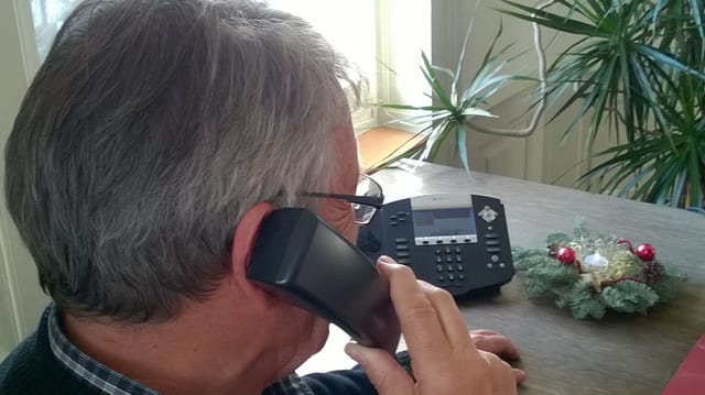 Ein Mann sitzt am Tisch und telefoniert Ein Mann sitzt am Tisch und telefoniert