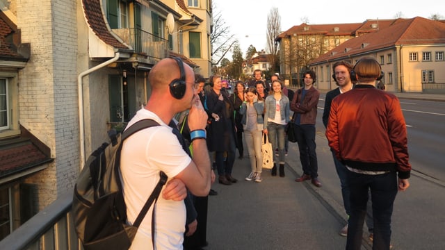 Gruppe mit Kopfhörern auf einem Trottoir. Gruppe mit Kopfhörern auf einem Trottoir.