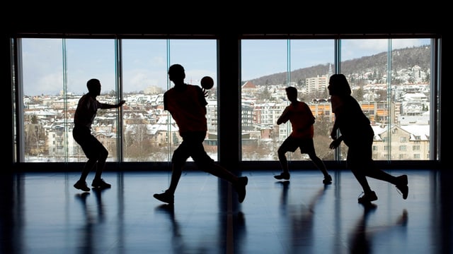 Turnhalle mit Handball spielenden Jugendlichen Turnhalle mit Handball spielenden Jugendlichen