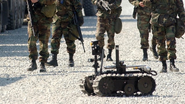Automatisches Waffensystem bei einer Militärübung. Im Hintergrund Armeeangehörige. Automatisches Waffensystem bei einer Militärübung. Im Hintergrund Armeeangehörige.