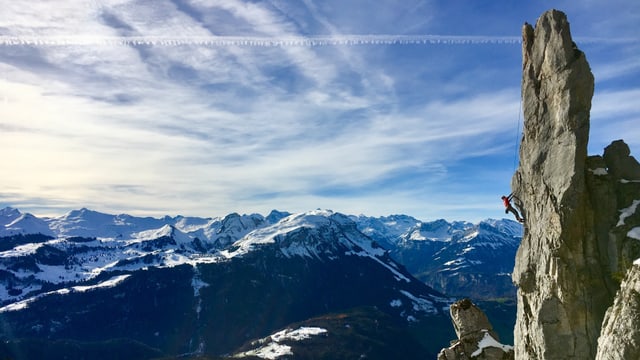 Ein Kletterer besteigt eine Felsnadel in der Region Mythen.
