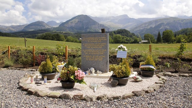 Ein Gedenkstein mit Blumen und Kerzen geschmückt. Ein Gedenkstein mit Blumen und Kerzen geschmückt.