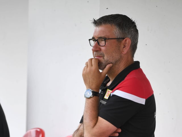 Urs Fischer sitzt auf einem Stuhl und greift mit der linken Hand an sein Kinn. Urs Fischer sitzt auf einem Stuhl und greift mit der linken Hand an sein Kinn.