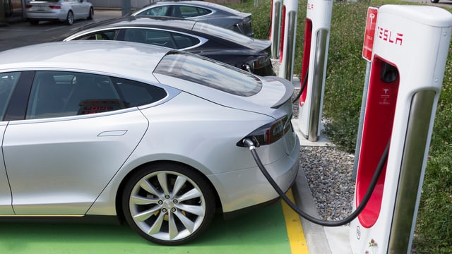 Tesla Model S an einer Schnellladestation am Tanken Tesla Model S an einer Schnellladestation am Tanken