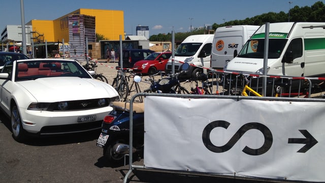 Hinweisschild mit Scope-Logo, daneben ein Cabrio und im Hintergrund ein Logistik-Gebäude des Hafens. Hinweisschild mit Scope-Logo, daneben ein Cabrio und im Hintergrund ein Logistik-Gebäude des Hafens.