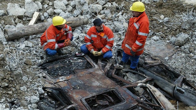 Ausgebranntes Auto unter Betontrümmern Ausgebranntes Auto unter Betontrümmern