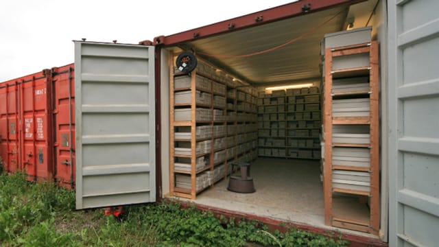In einem alten Container lagern in Holzregalen alte steinerne Fundstücke aus dem Altertum. In einem alten Container lagern in Holzregalen alte steinerne Fundstücke aus dem Altertum.