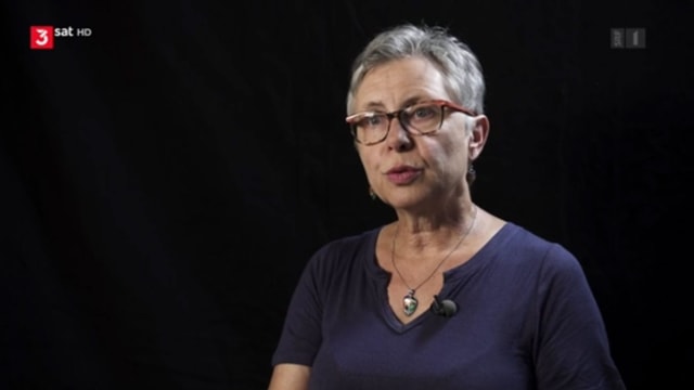 Eine Frau mit grauem Haar vor schwarzem Hintergrund. Eine Frau mit grauem Haar vor schwarzem Hintergrund.