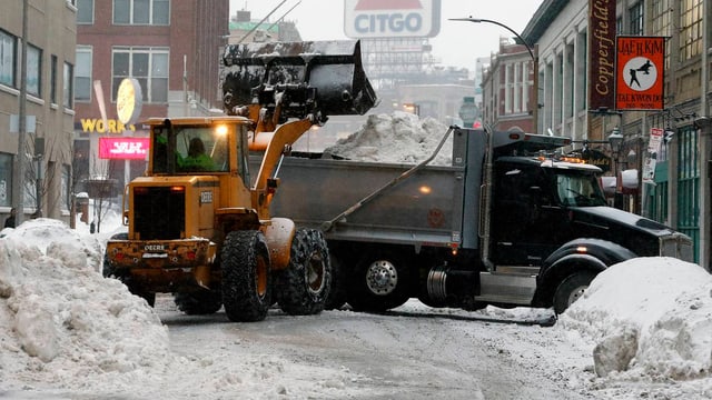 Mit Pneuladern werden die Schneemassen aus den Strassen auf Lastwagen geladen. Mit Pneuladern werden die Schneemassen aus den Strassen auf Lastwagen geladen.