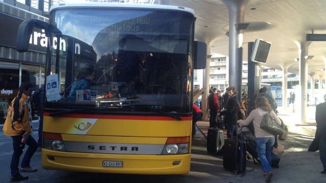 Postauto mit Fahrgästen, die einsteigen. Postauto mit Fahrgästen, die einsteigen.
