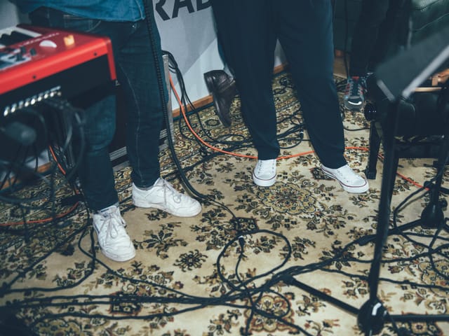 Popstar- und Moderatorenuniform: Dunkle Hosen, weisse Sneakers.