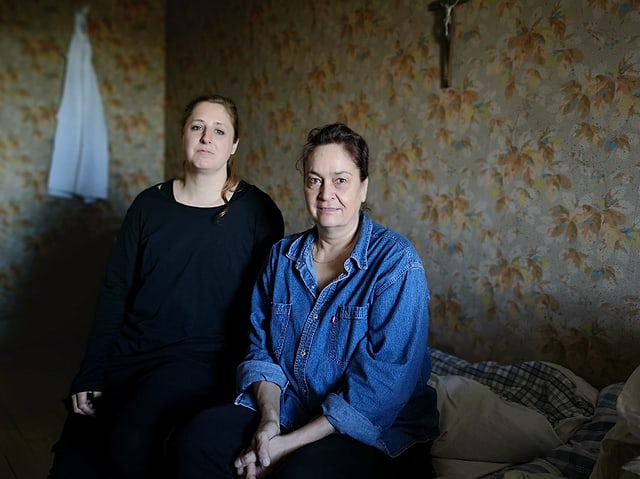 Zwei Frauen sitzen auf einem Bett. Zwei Frauen sitzen auf einem Bett.