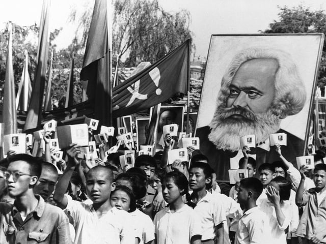 Jugendliche Rotgardisten ziehen 1966 mit der Mao-Bibel und einem Marx-Porträt durch die Strassen.