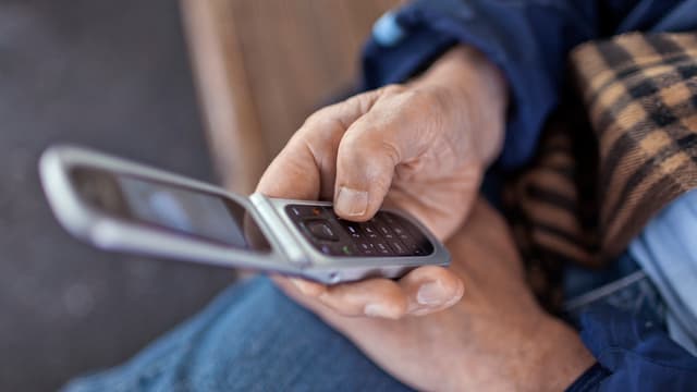 Ein Mann tippt eine Nummer in sein Handy. Ein Mann tippt eine Nummer in sein Handy.