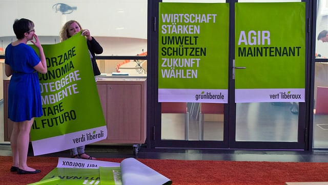 Frauen hängen Plakate auf Frauen hängen Plakate auf