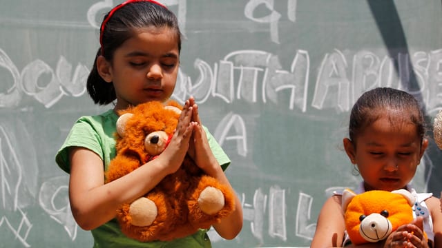 Mädchen betend mit einem Teddy-Bären. Mädchen betend mit einem Teddy-Bären.