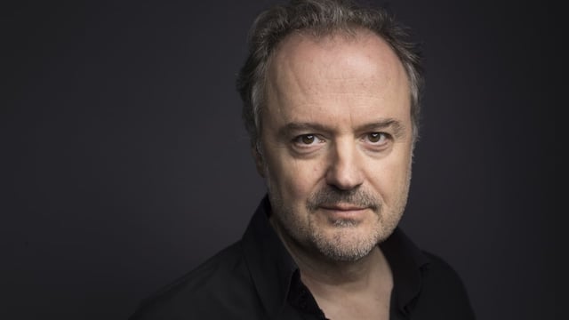 ein Mann vor einem schwarzen Hintergrund ein Mann vor einem schwarzen Hintergrund