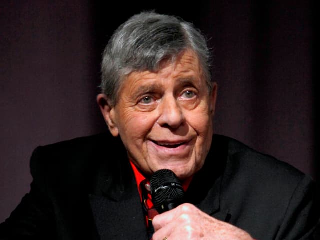 Komiker Jerry Lewis steht an einem Rednerpult. Komiker Jerry Lewis steht an einem Rednerpult.