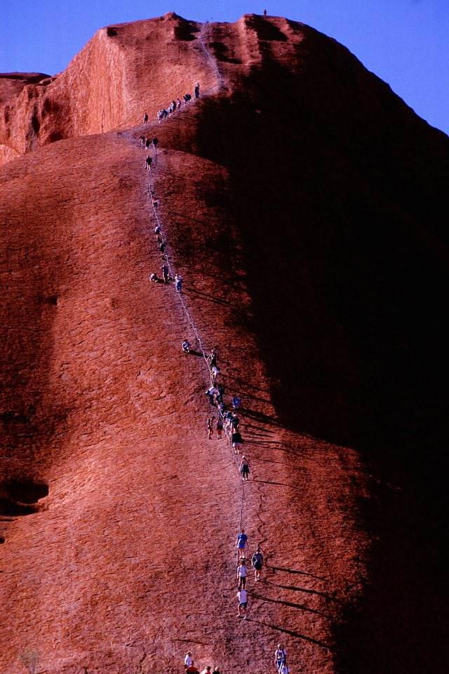 Touristen steigen auf den Heiligen Berg der Aborigines Touristen steigen auf den Heiligen Berg der Aborigines